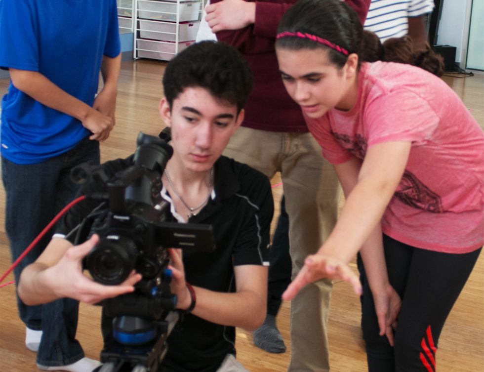 Student directing a scene while a classmate runs camera