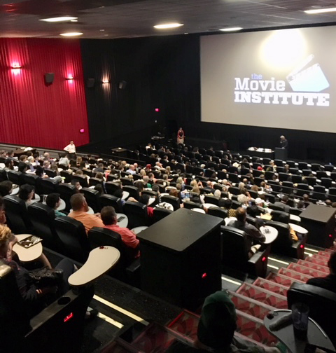 A full movie theater with The Movie Institute logo on the screen